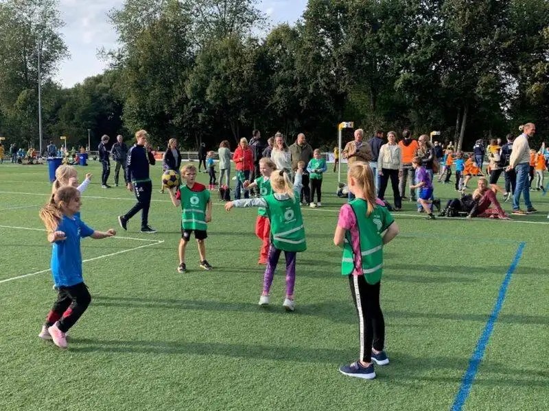 Verschillende kinderen op een grasveld aan het sporten