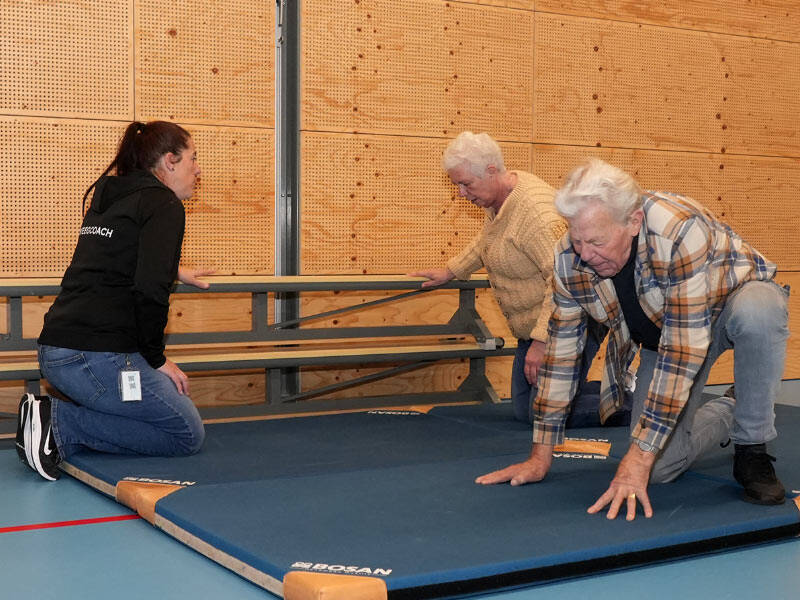 mensen die samen met een instructeur opstaan trainen na een valpartij